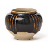 A SMALL CIZHOU TYPE BLACK GLAZED RIBBED JAR