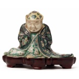 A 'FAMILLE VERTE' BISCUIT FIGURE OF A SEATED IMMORTAL