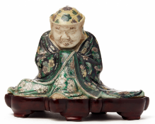 A 'FAMILLE VERTE' BISCUIT FIGURE OF A SEATED IMMORTAL