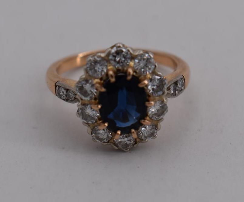 Bague en or sertie d'un saphir central dans un entourage de diamants brillantés. - [...]