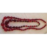Two strings of Cherry Amber/Bakelite Beads - 17" L and 35 grams and 23" long and 38 grams.