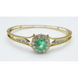 An emerald and diamond set bangle, set with eighteen diamonds,