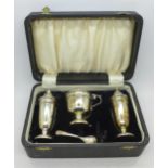 A three piece silver condiment set, cased,