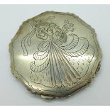 A white metal compact with decoration to the lid,