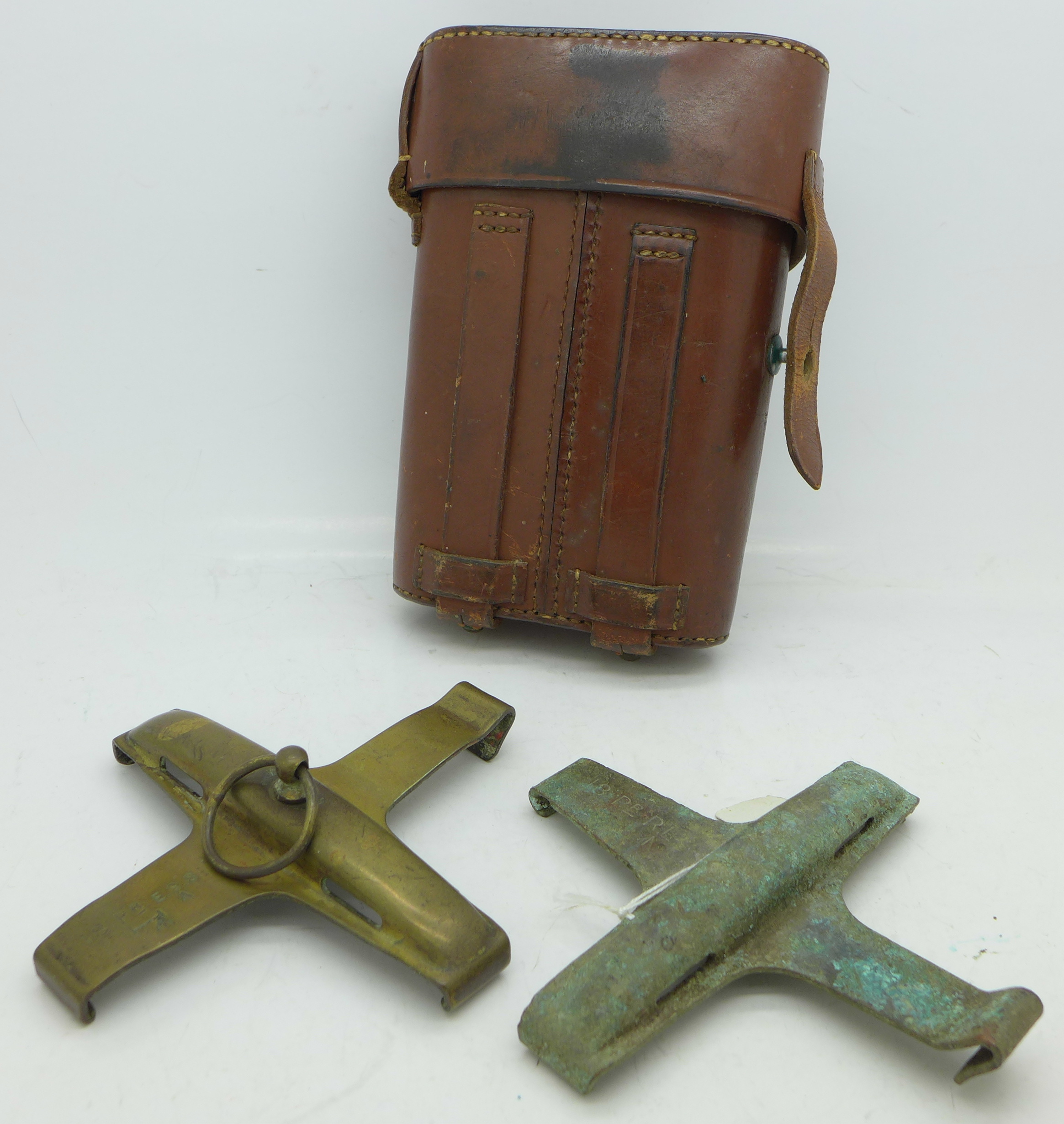 Two WWI British 18 pounder brass safety clips in a leather pouch