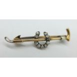 A Victorian horseshoe and riding crop brooch in yellow metal, set with ten old cut diamonds,