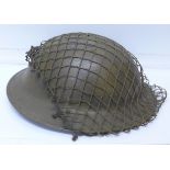 A WWII British helmet with netting and liner