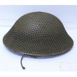 A WWII British helmet with netting and liner,