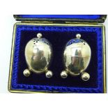 A pair of silver peppers, cased,