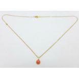 A yellow metal chain with a coral set pendant
