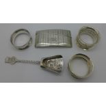 A silver card case, three silver napkin rings and a scoop,