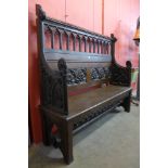 An Arts and Crafts carved oak settle