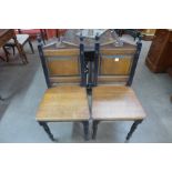 A pair of Victorian oak and ebonised hall chairs