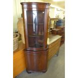 A mahogany freestanding serpentine corner cabinet