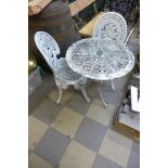 A cast aluminium garden table and two chairs