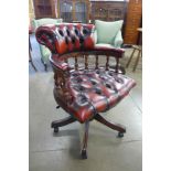 A mahogany and oxblood leather office chair