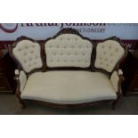 A Victorian carved walnut and upholstered chair back settee