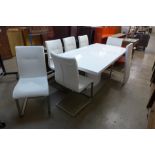 A white high gloss extending dining table and six chairs