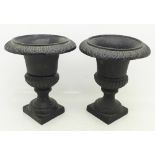 A pair of cast metal urns,