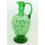 A green glass ewer decorated with enamel flowers,