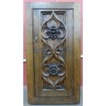A small Victorian Gothic Revival carved oak single door cupboard