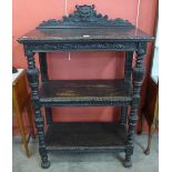 A Jacobean Revival carved oak three tier buffet