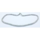 A grey cultured pearl necklace with silver clasp