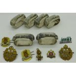 Military badges and a set of six regimental napkin rings