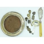 A silver caddy spoon, four silver salt spoons, a silver circular picture frame, a/f,