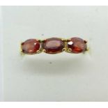 A yellow metal and garnet ring, hallmark worn, 1.