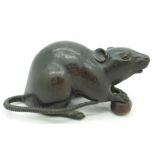 A Japanese bronze model of a rat holding a nut, tail restored at the base, signed, length 16.