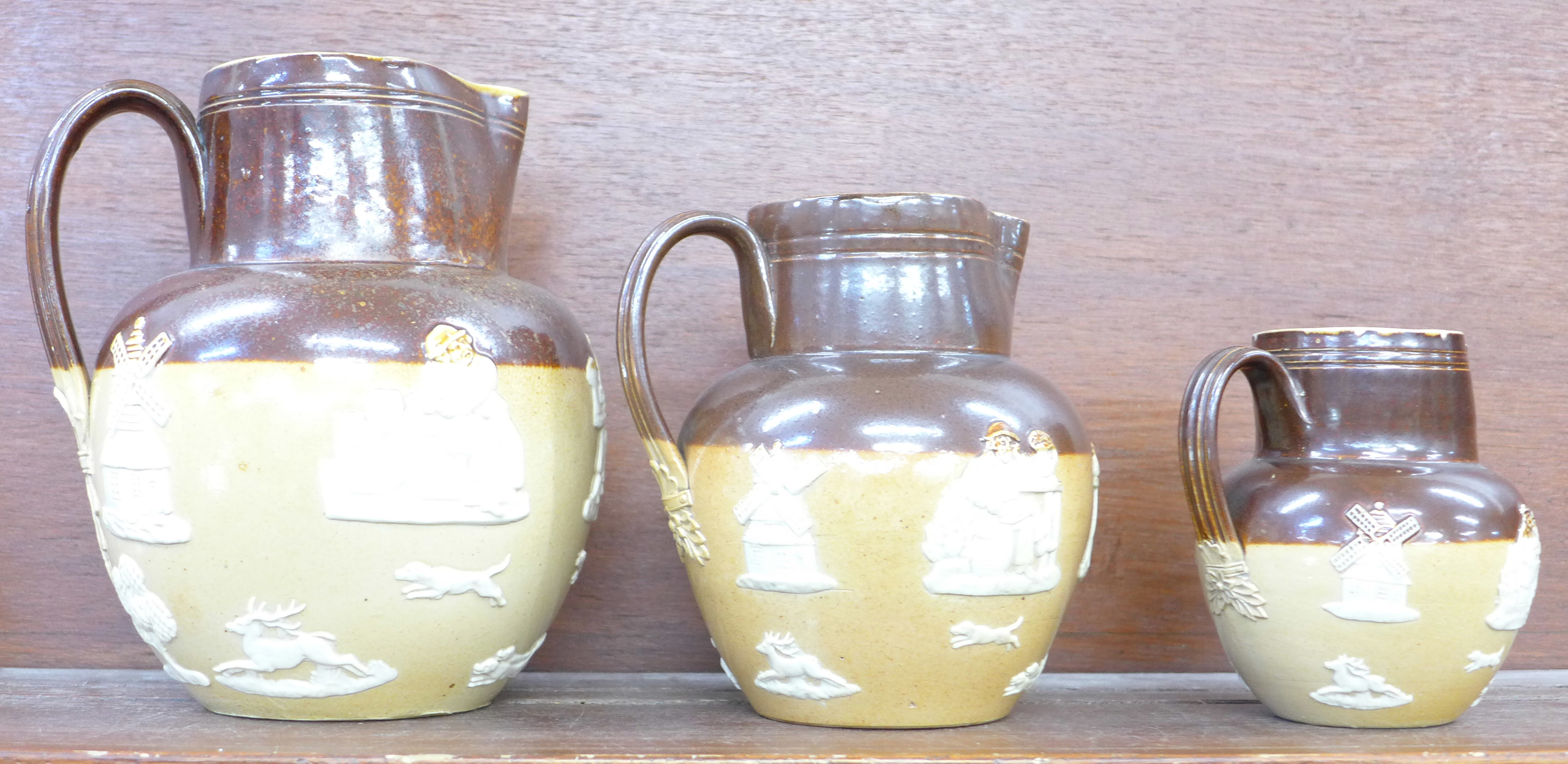 Three graduated Royal Doulton jugs,