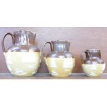 Three graduated Royal Doulton jugs,