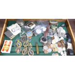 Assorted items including military cap badges, coins, wristwatches, etc.