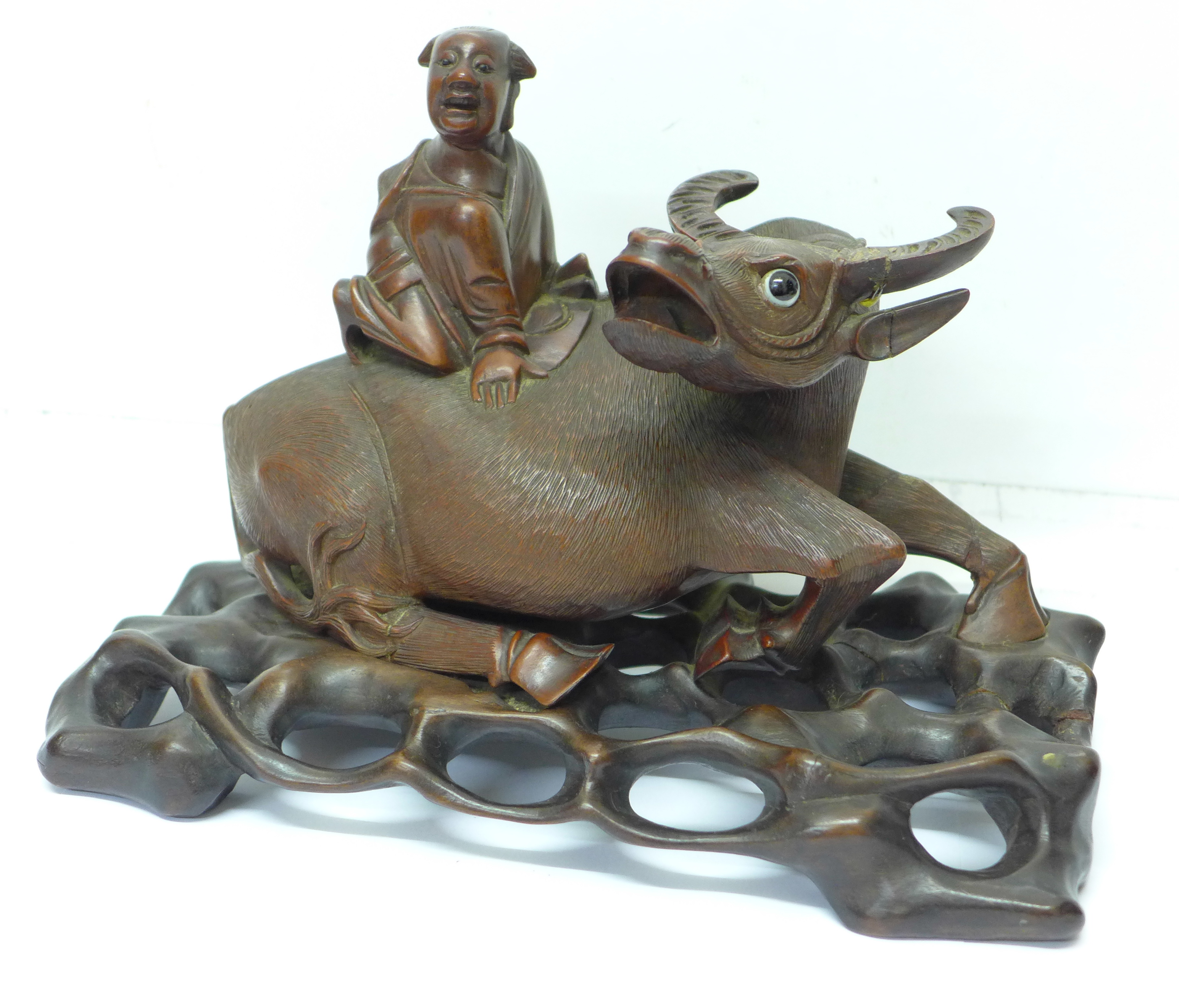 A 19th Century carved oriental wooden figure, boy with water buffalo,