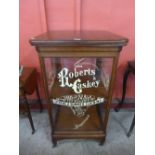 A beech shop display cabinet, bearing Roberts & Caskey,