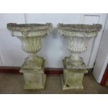 A pair of large concrete campana garden urns on stands