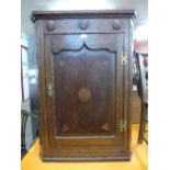 A George III oak wall hanging corner cupboard