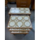 A teak and tiled topped coffee table and matching nest of tables