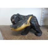 A carved wooden figure of a bear and salmon