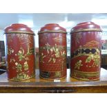A set of three red chinoiserie tea canisters and covers