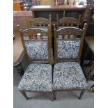 A set of four Art Nouveau carved oak and upholstered dining chairs