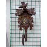 A Black Forest cuckoo clock and a 19th Century cast iron mantel timepiece