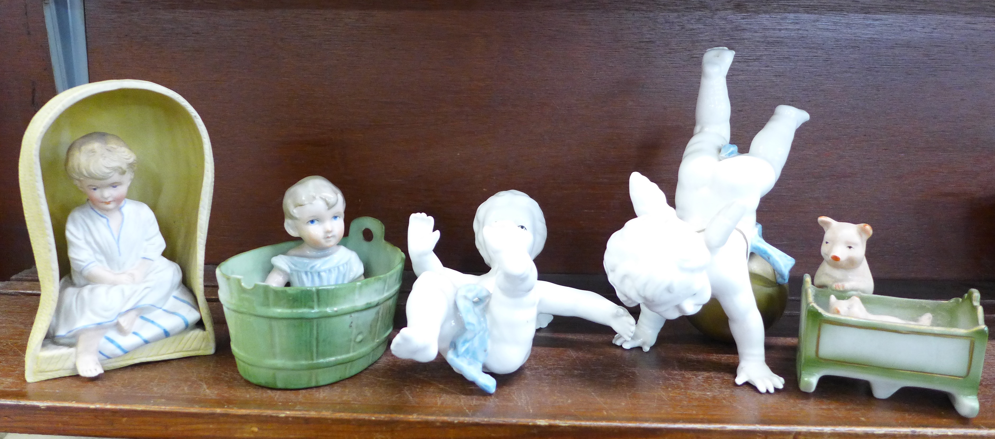 Two piano baby figures, a bisque figure and two other continental figures,