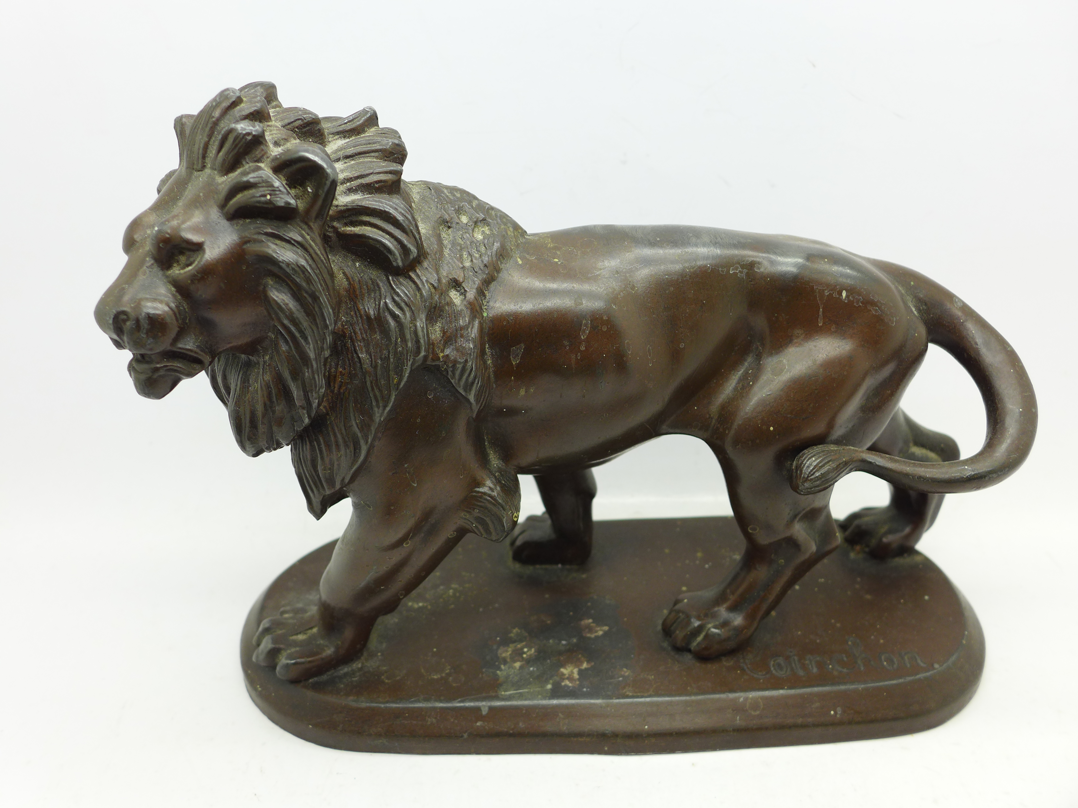 A cast metal figure of a lion signed Coinchon,