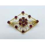 A hallmarked 18ct gold brooch set with red stones, 9.