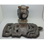 A carved hardwood figure of a chimpanzee and an African hardwood warrior's mask,