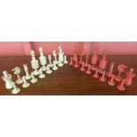 A 19th Century carved red and white ivory Barleycorn chess set,