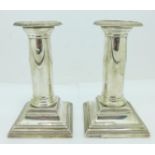 A pair of silver candlesticks with weighted bases, 12.