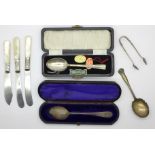 Three silver spoons, silver sugar bows and three mother of pearl handled knives,